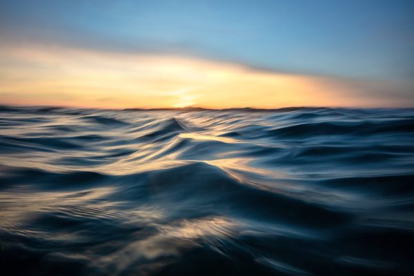 Sunset over the ocean with wavy water
