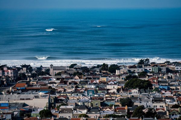 Luxury San Francisco wall fine art featuring the Sunset District residential skyline overshadowed by a massive large wave at Ocean Beach, limited edition photography by Fred Pompermayer.